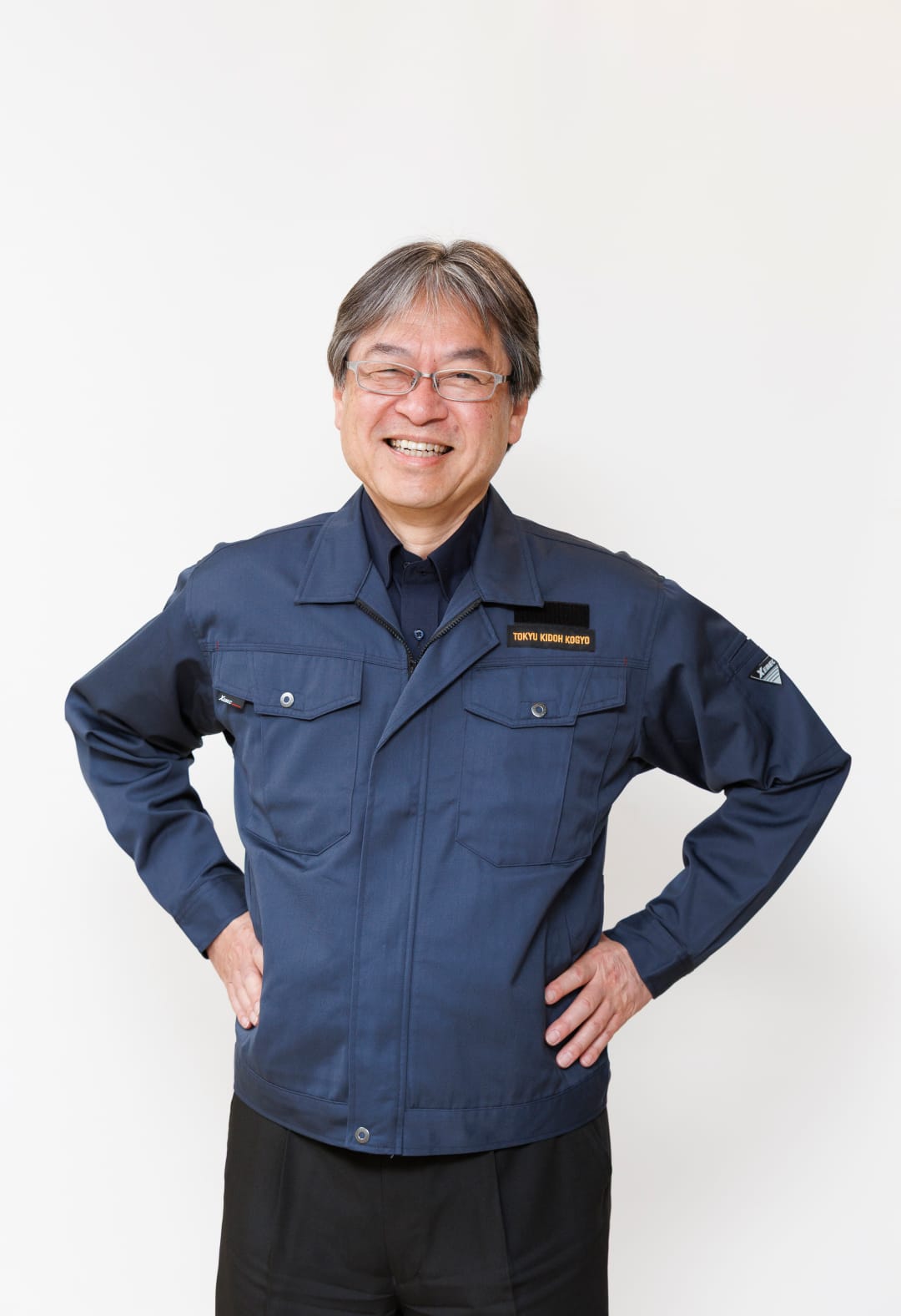 取締役社長が笑顔で正面を向いて立っているポートレート写真