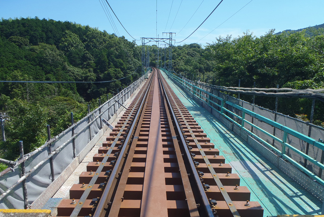 夜の線路上を走行しながら火花を散らして走行している特殊な鉄道保守車両